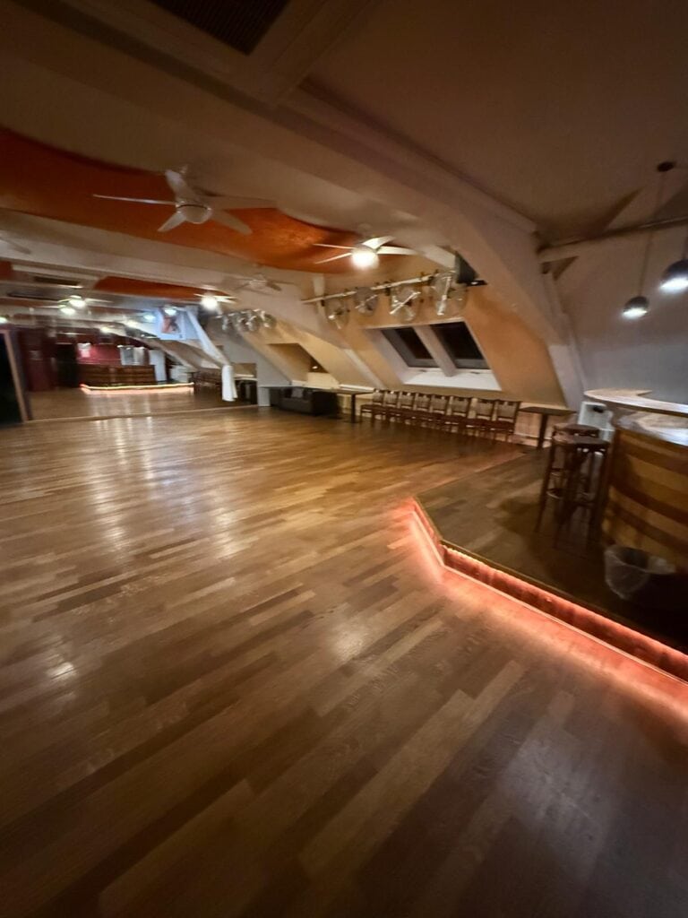 Geräumiger Tanzraum mit Holzfußboden und moderner Beleuchtung bei Salsa Mara Tübingen.