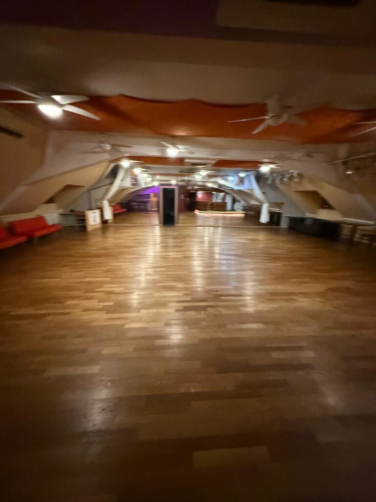 Unser großer Tanzraum bei Salsa Mara in Tübingen bietet viel Platz zum Tanzen. Ausgestattet mit hochwertigem Holzparkett und dekorativer Deckenbeleuchtung, eignet er sich perfekt für Salsa, Bachata und Kizomba Workshops, Tanzpartys oder private Tanzstunden. Ideal für Anfänger und erfahrene Tänzer.